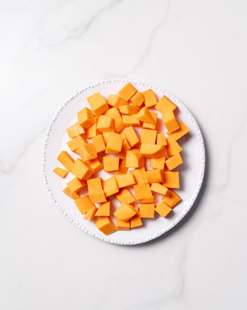 Sweet potatoes cut into cubes on a white plate.