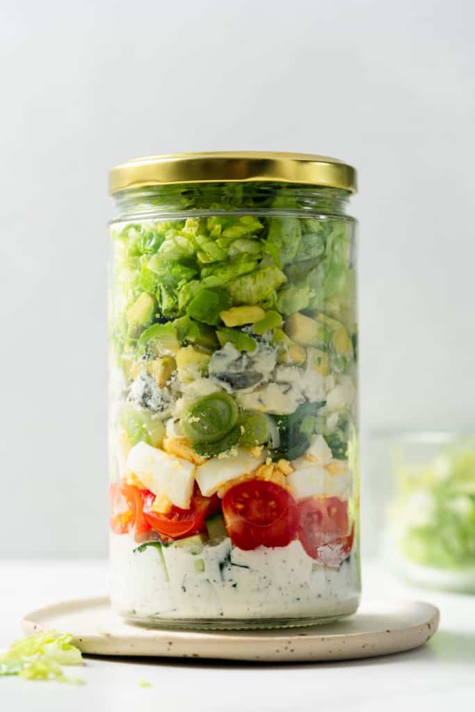 Vegetarian cobb salad jar closed with a gold lid.