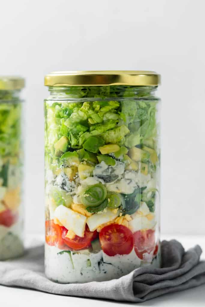 side shot of cob salad in a jar with lid on it