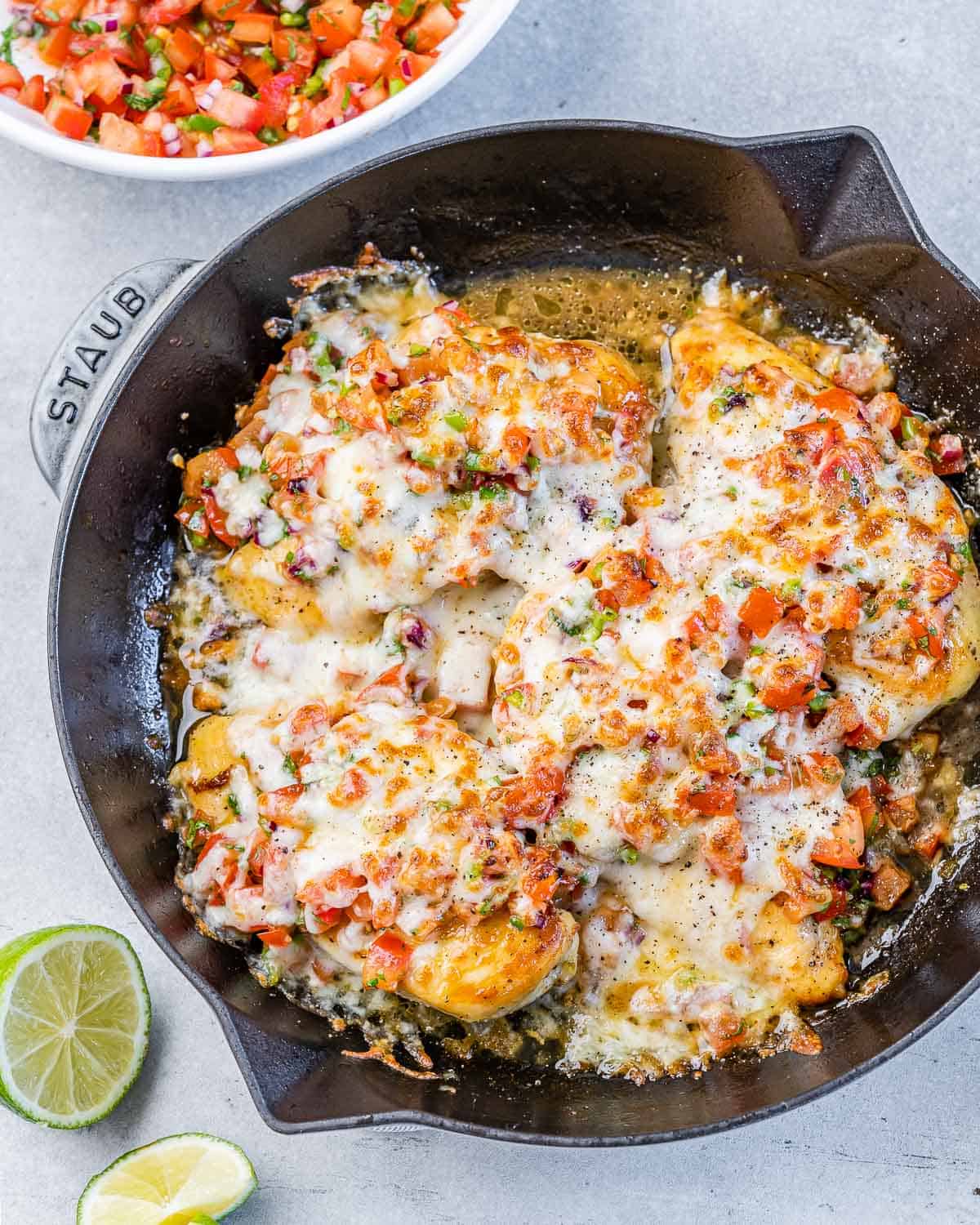 top view baked chicken breast topped with salsa and melted cheese