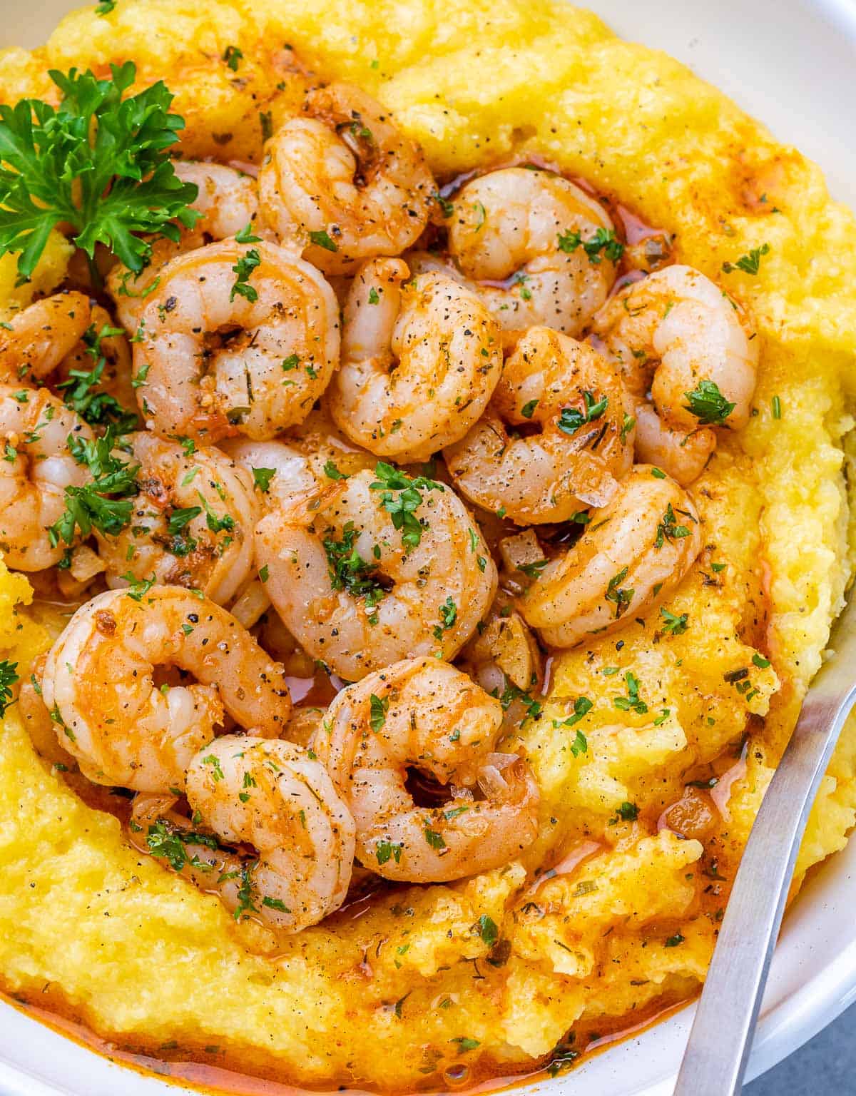 Closeup view of Shrimp and Grits garnished with fresh parsley.