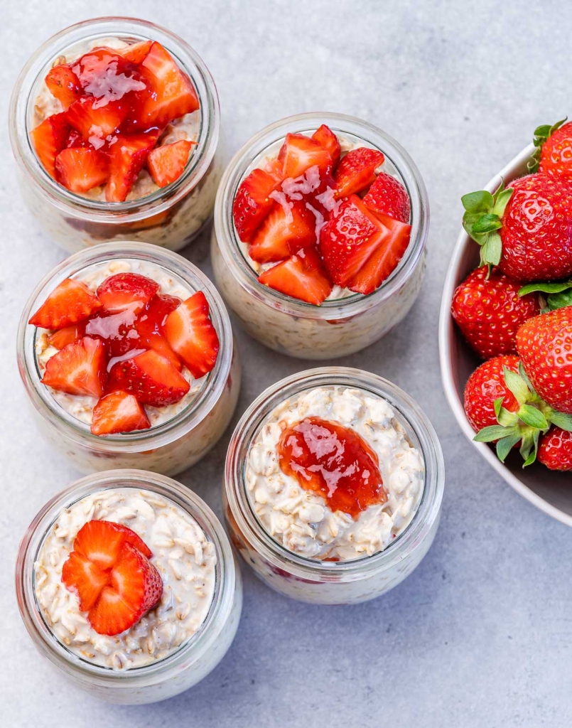 Jars filled with overnight oats and strawberries on top.