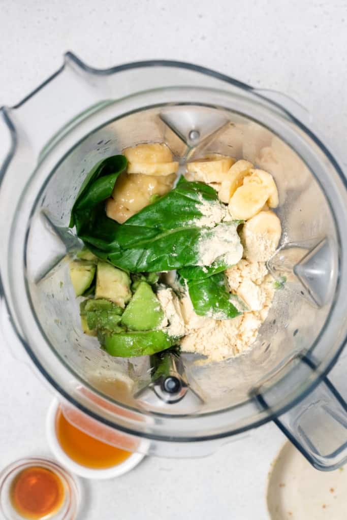 Sliced banana, avocado and spinach in a blender.