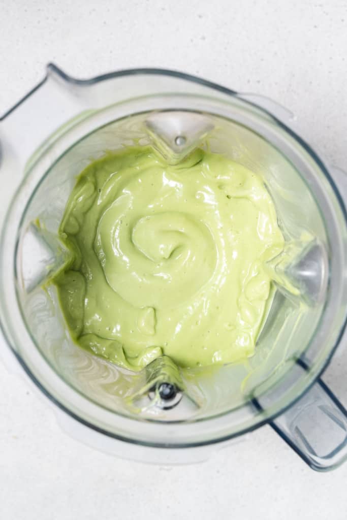 Blended avocado smoothie in a blender.
