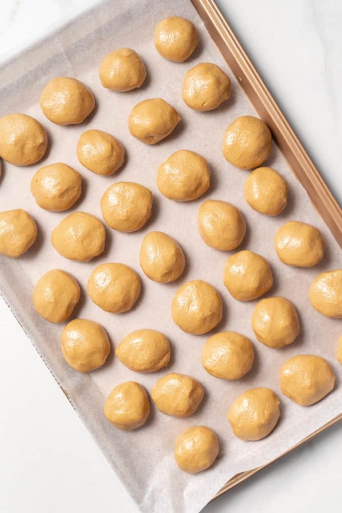 top view of peanut butter balls lined up on a pan