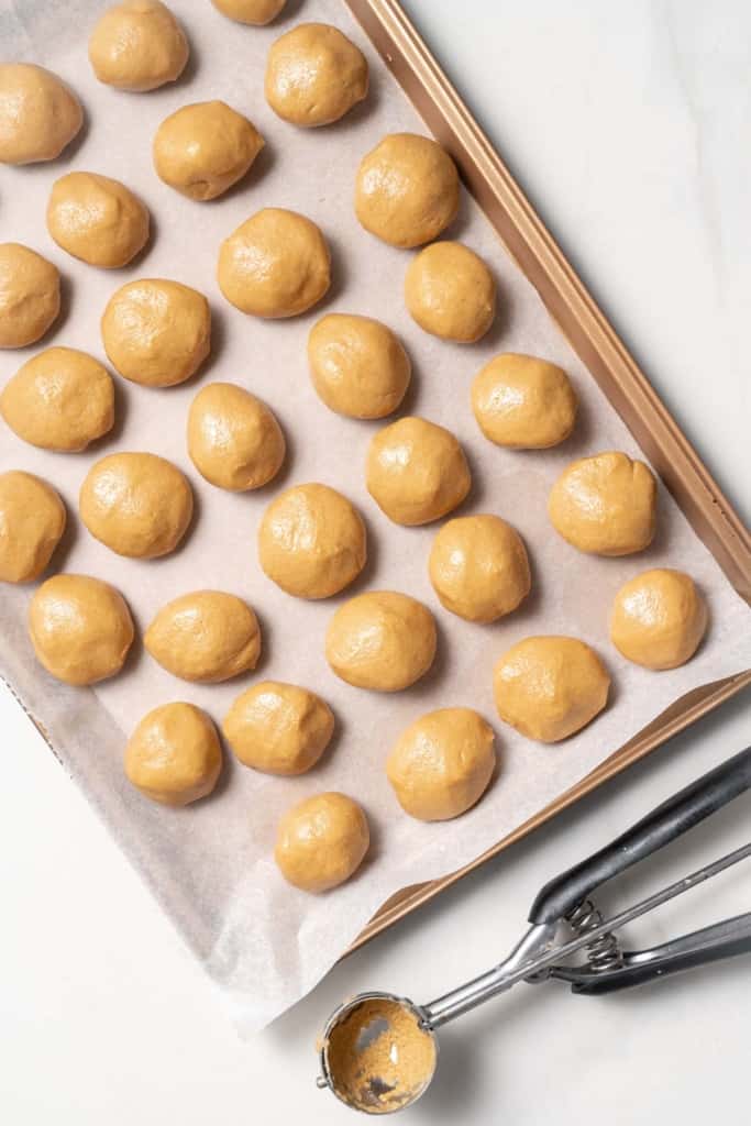 Peanut butter balls on a cookie sheet.