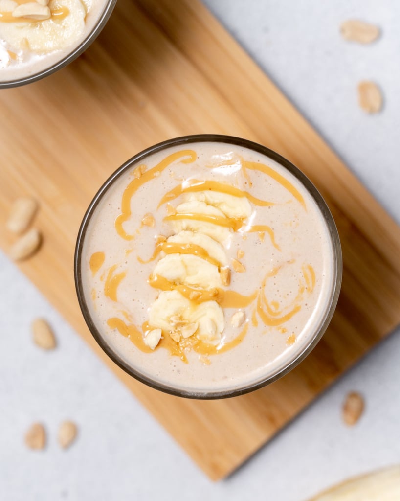 Peanut butter banana smoothie topped with banana slices and drizzled with peanut butter.