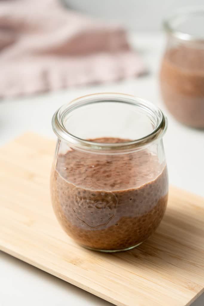Chocolate chia seed pudding in a small glass jar.