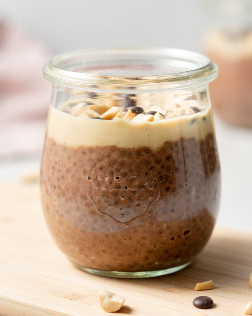 side shot of chia pudding in a jar top with peanut butter and chocolate chips 