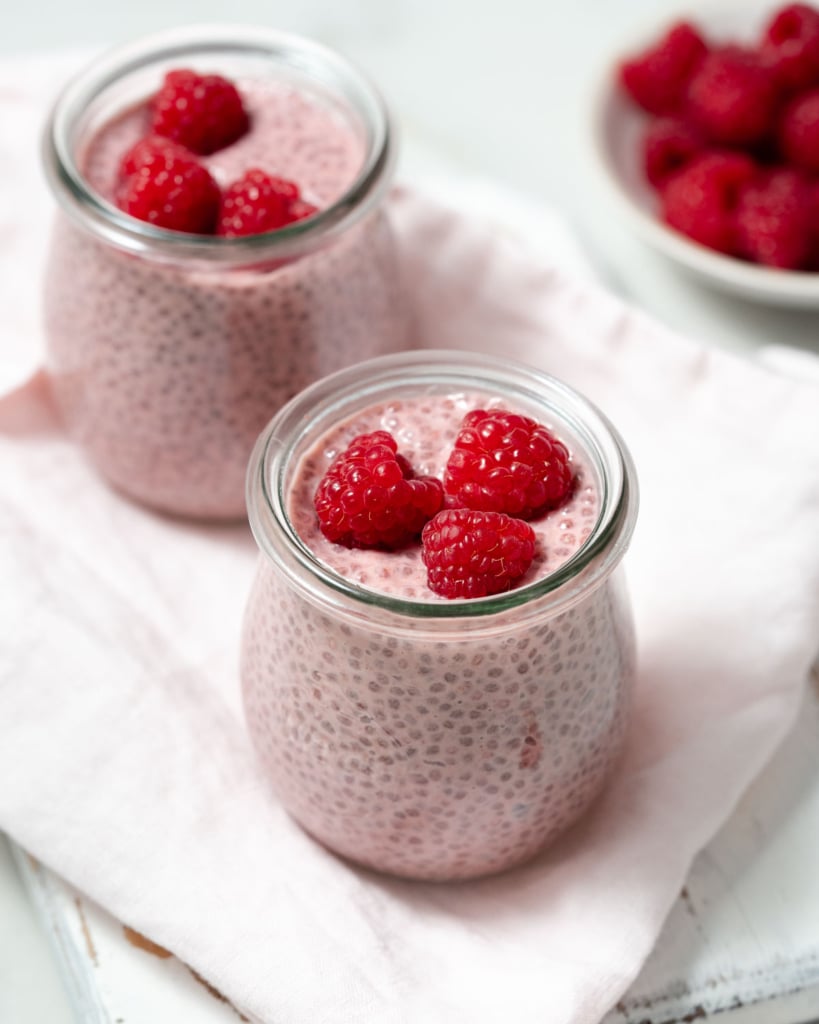 side shot of chia pudding in a jar topped with raspberry 