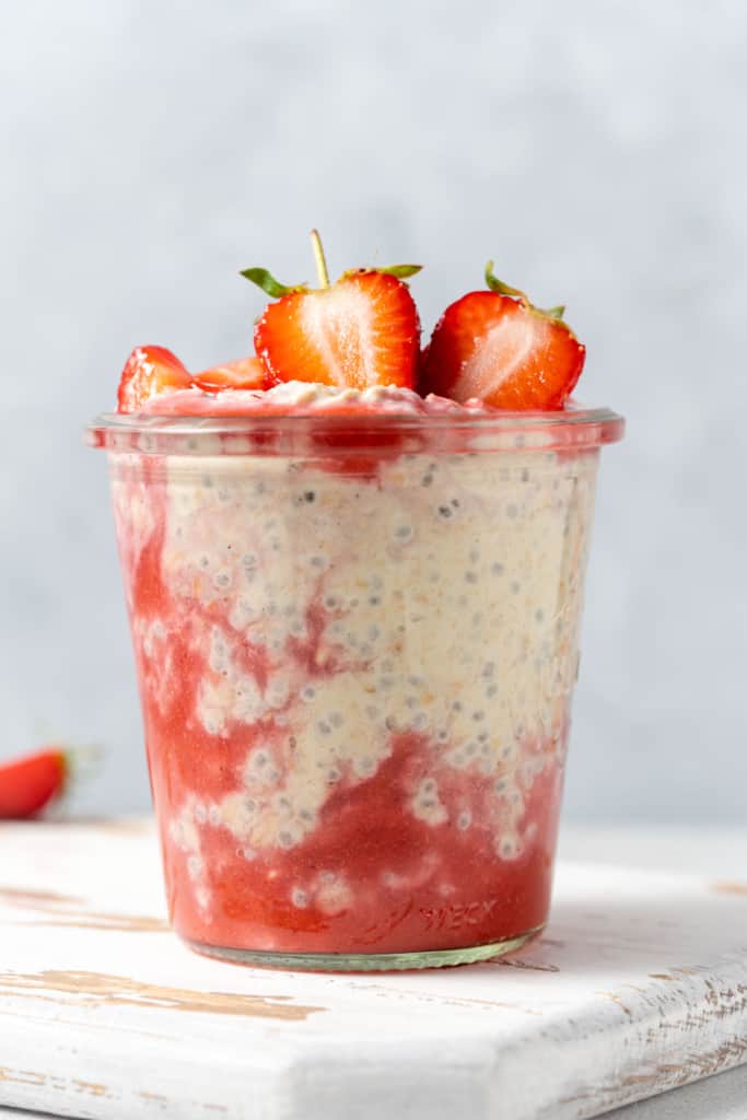 side shot of overnight oats with strawberries in a jar