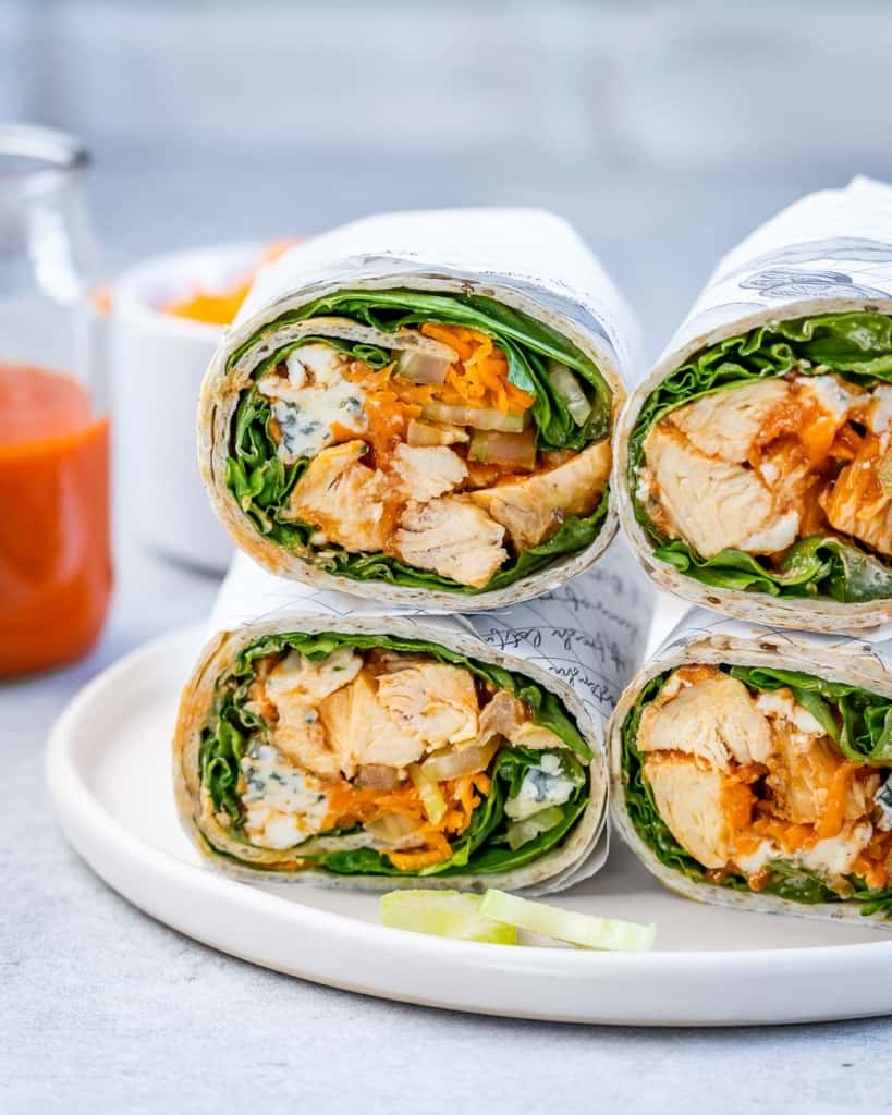 side shot of 4 chicken wraps on a white plate 