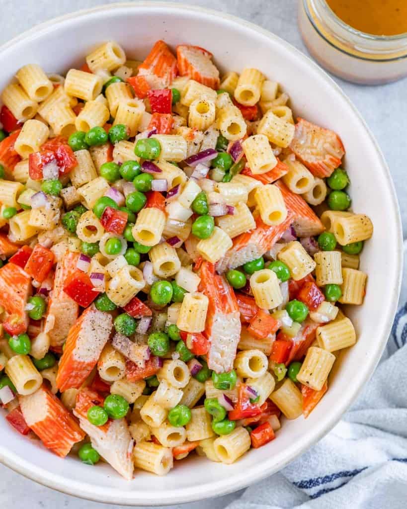 Pasta salad tossed with crab, peas and red onion.