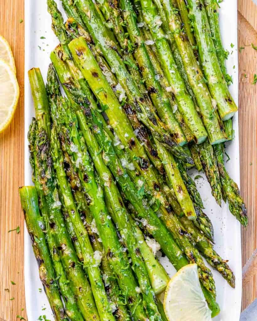 Grilled asparagus served on a white plate.
