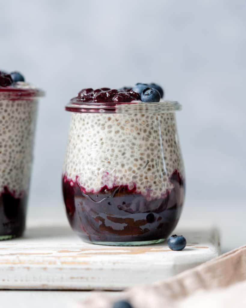 side shot of blueberry chia pudding in a jar topped with fresh blueberries