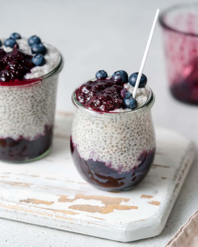side shot of blueberry chia pudding with spoon in jar