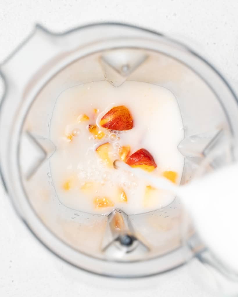 Peaches and milk in a blender.