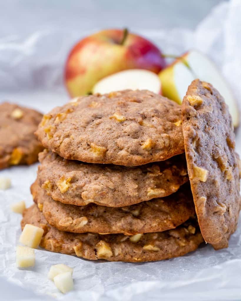 Stack of apple cookies near a fresh apple.