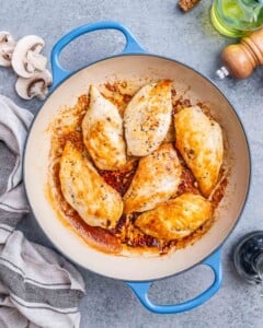 Seared chicken breast in a pan.