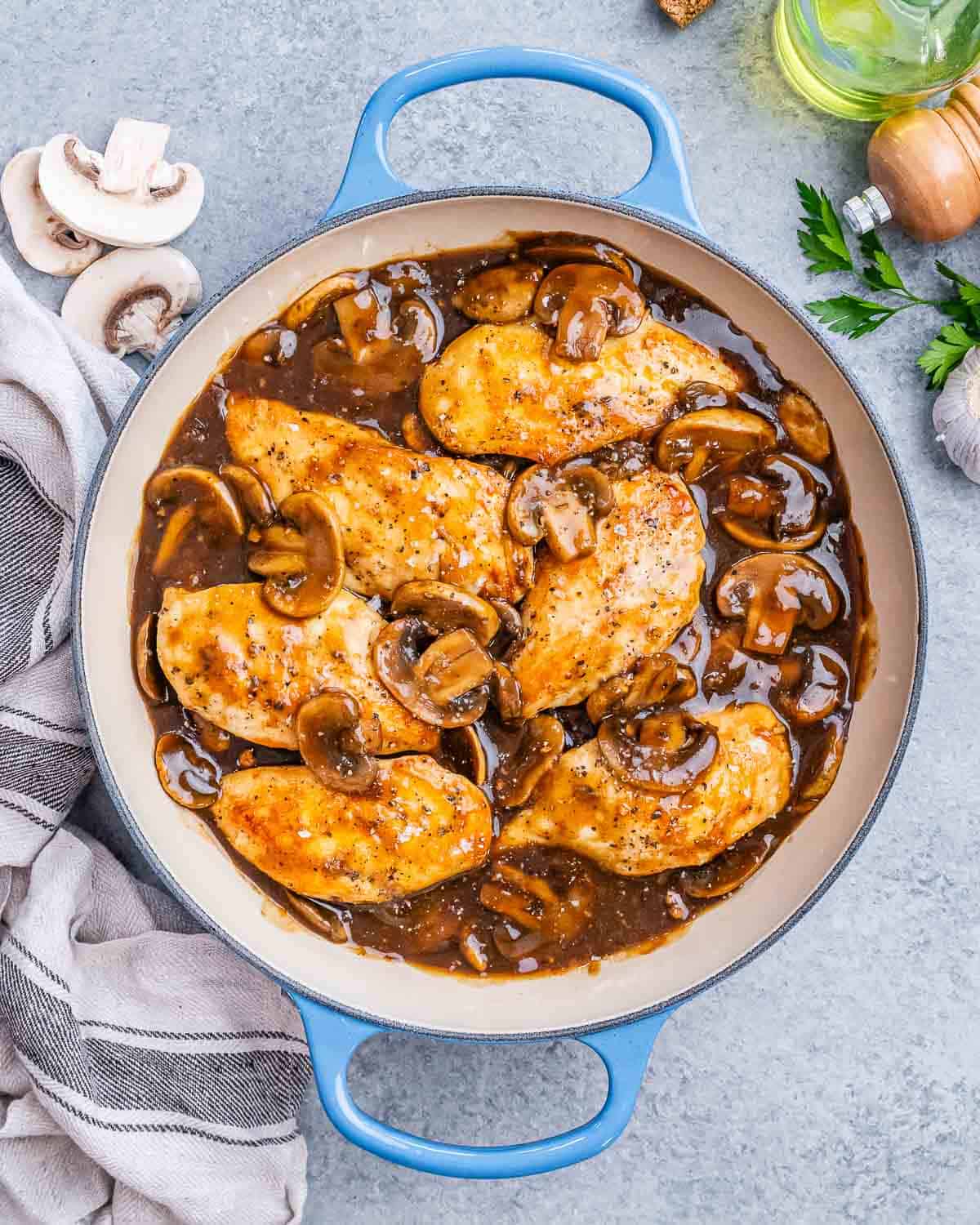a blue skillet with chicken in a mushroom sauce.