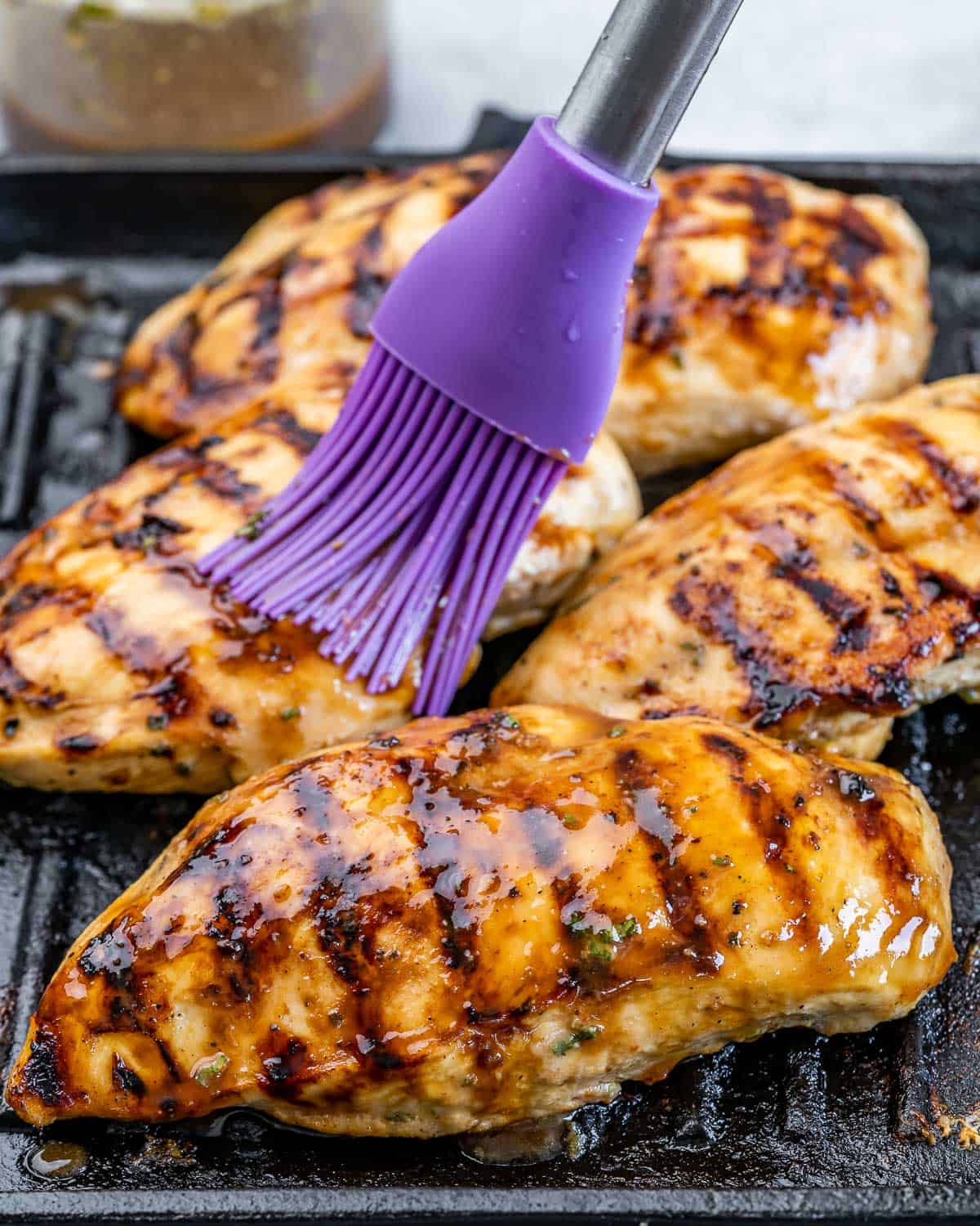 Basting chicken on a grill pan.