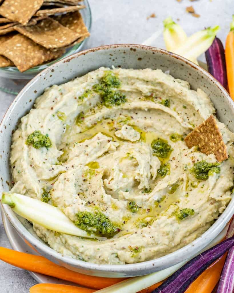 White bean dip served with crackers and freshly cut veggies.