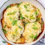 top view of 4 baked chicken breasts on a skillet topped with melted cheese