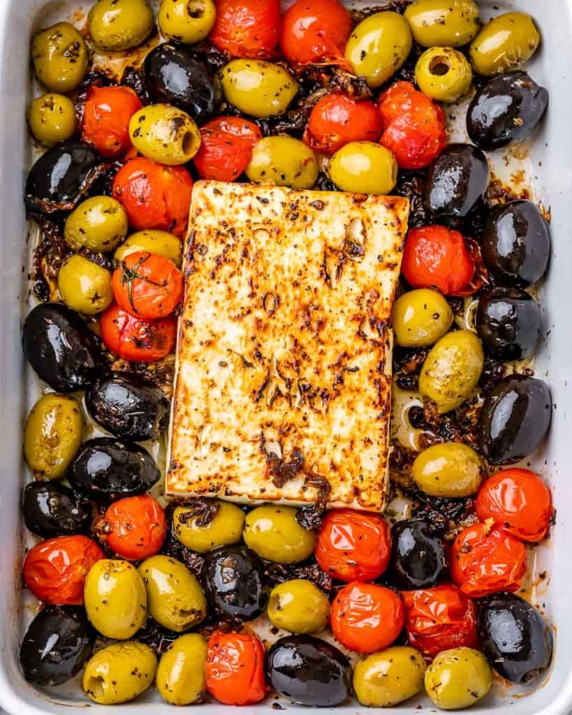 top view close up of baked feta cheese with olives and tomatoes