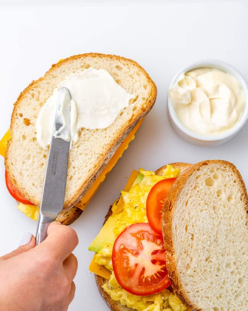 Spreading mayo on the outside of a sandwich.