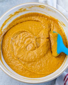 Stirring together pumpkin batter in a large bowl.