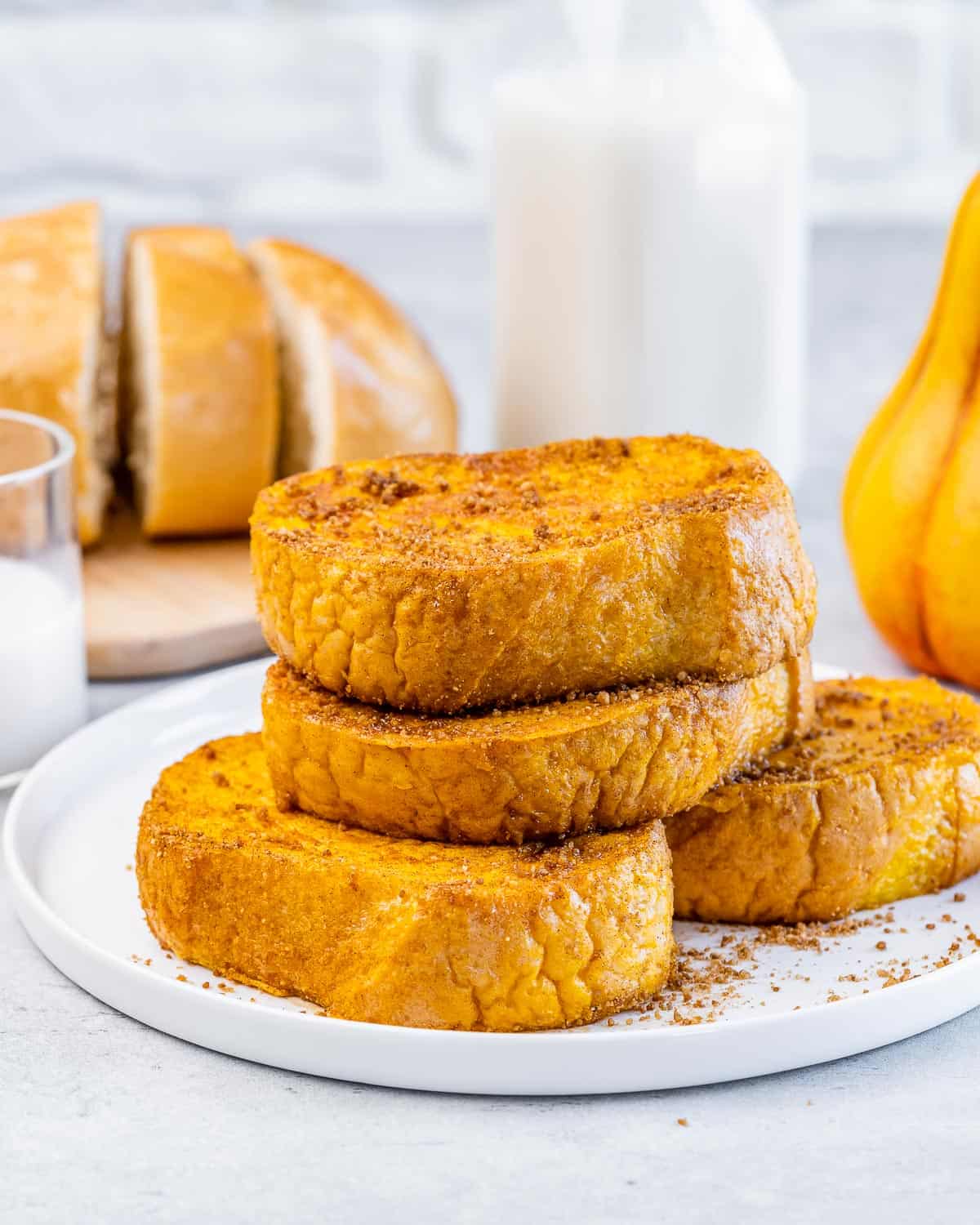 Pieces of pumpkin French toast stacked on a white plate.