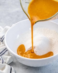 Pouring pumpkin mixture into flour mixture.