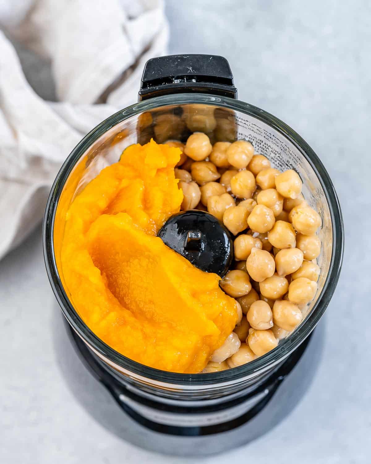 Chickpeas and pumpkin puree in a food processor.