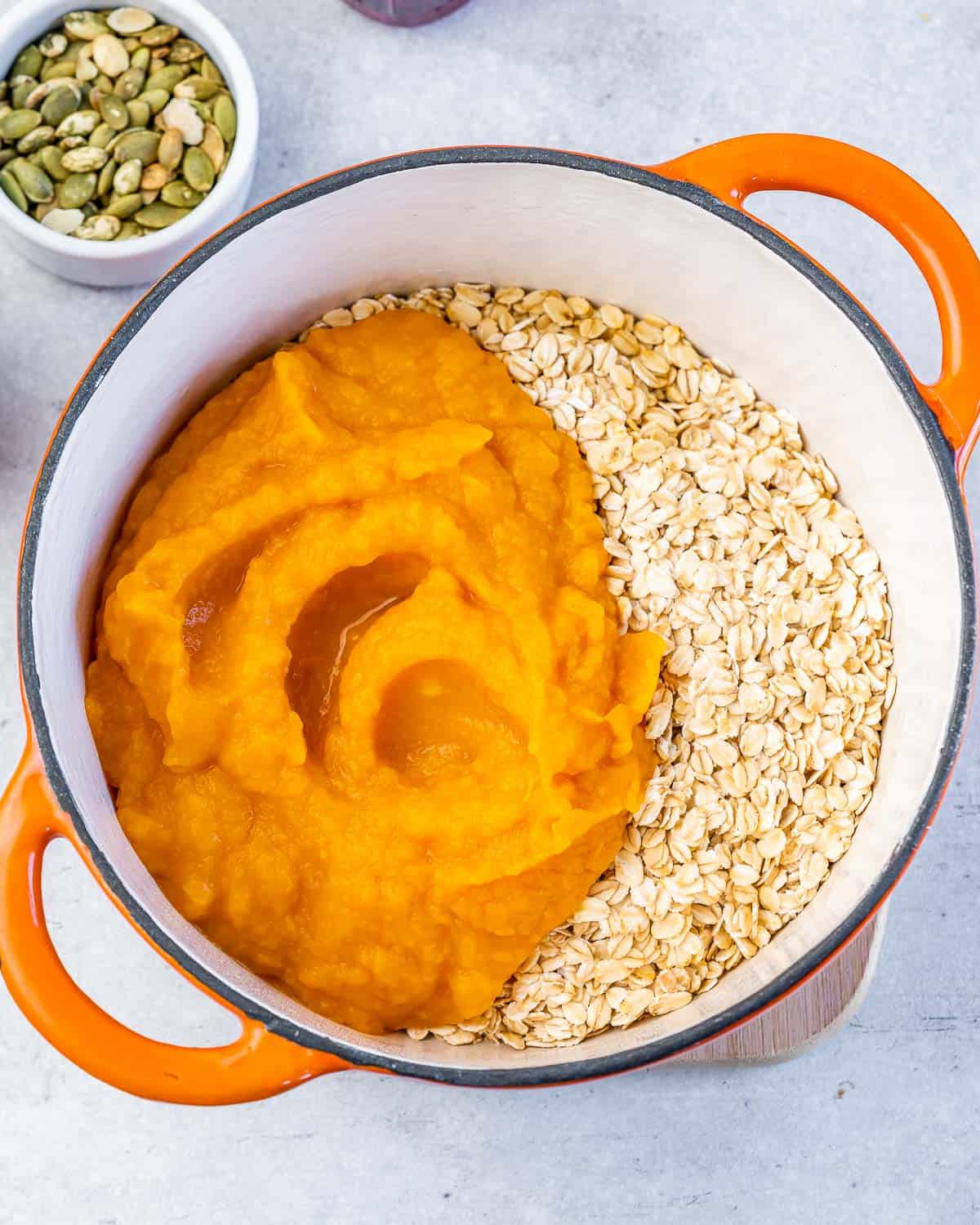 Pumpkin puree and rolled oats combined in a large pot.