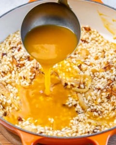Pouring pumpkin sauce into rice mixture.