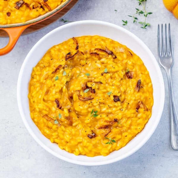Top view pumpkin risotto in a white round bowl.