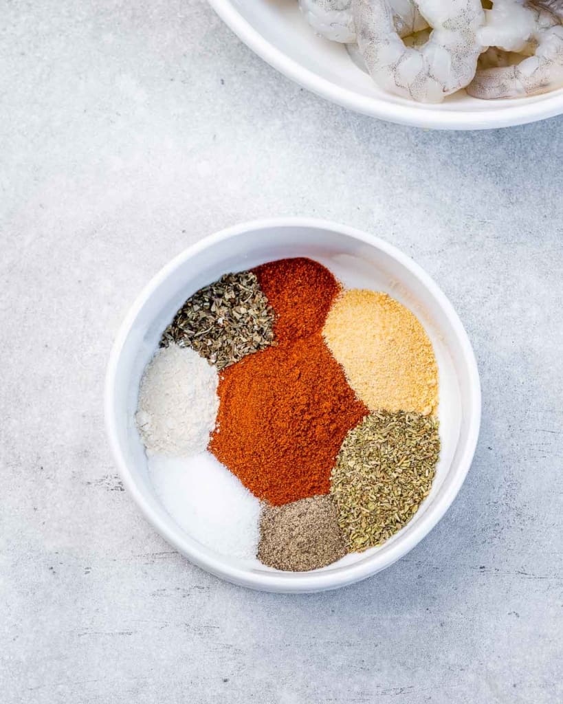 A variety of spices in a white bowl.