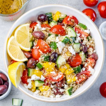 top view of a white bowl with quinoa greek based salad