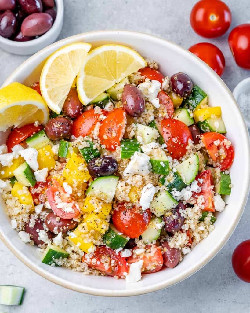 top view quinoa salad with olives and feta cheese in a white round bowl