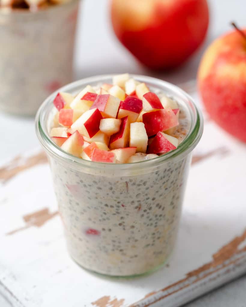 side top view of a jar of overnight oats topped with chopped red apples 