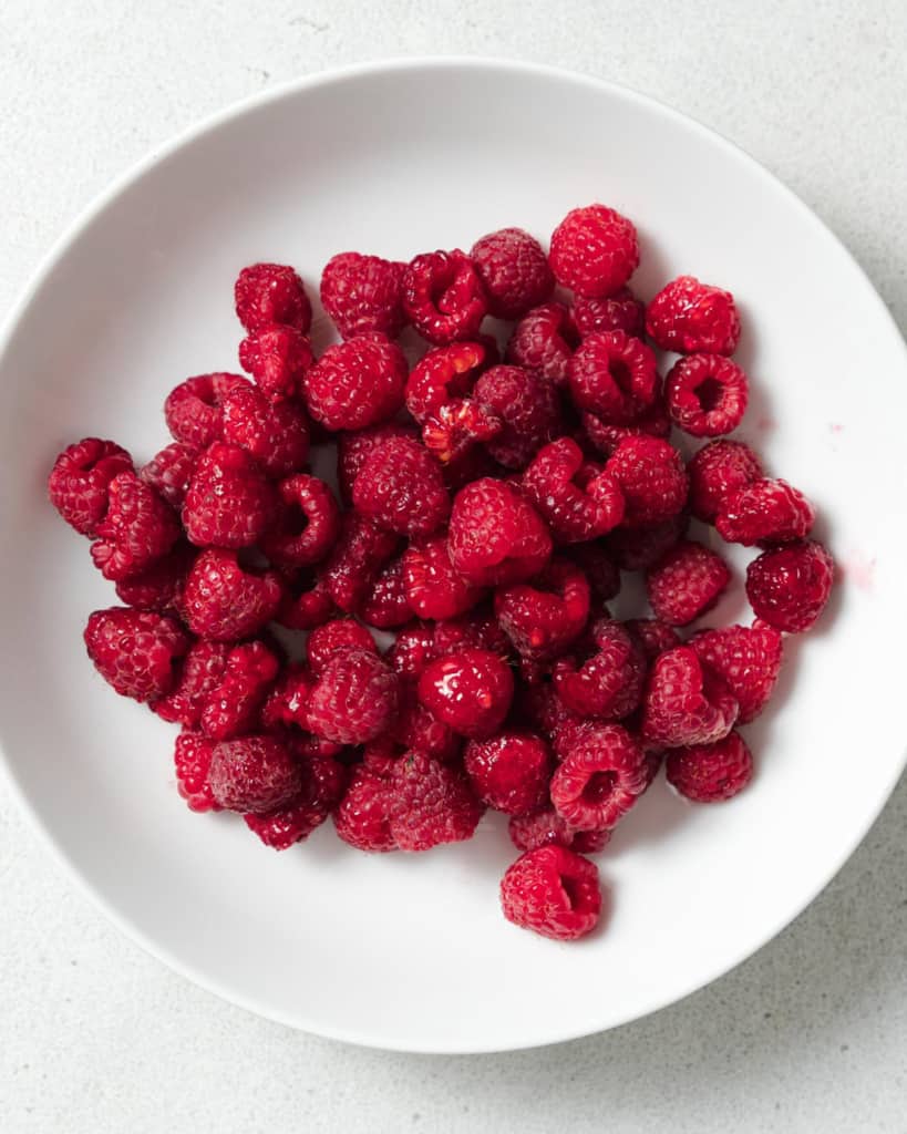 Raspberries in a white bowl.