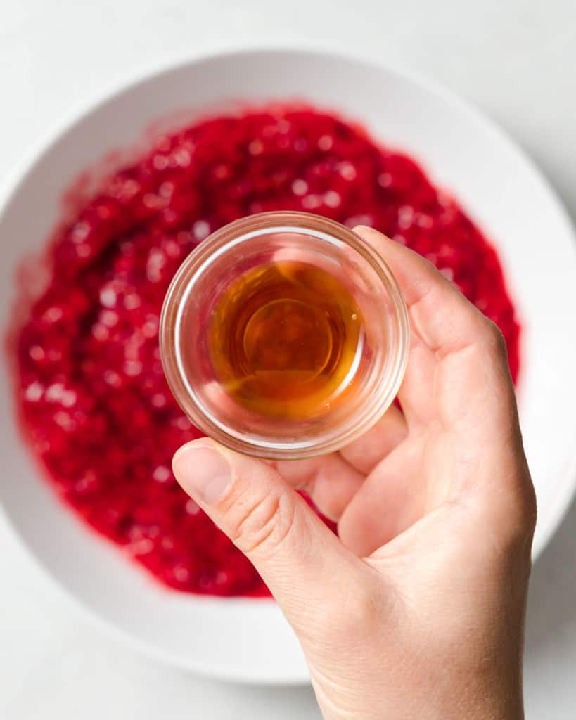 Adding maple syrup to mashed raspberries.