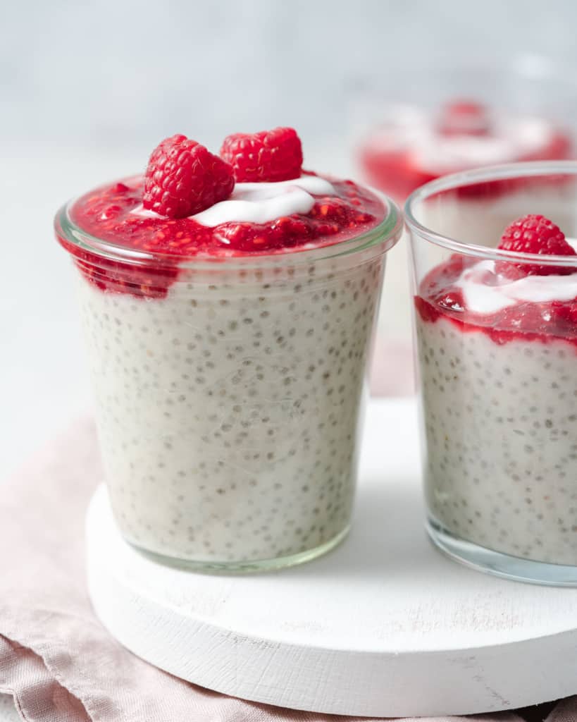 side shot of 3 jars of yogurt chia pudding topped with mashed berries 