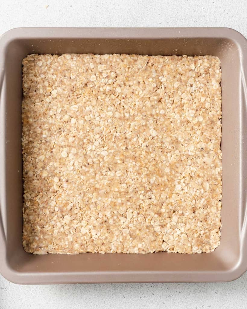 Oat crumble crust in the bottom of a pan.