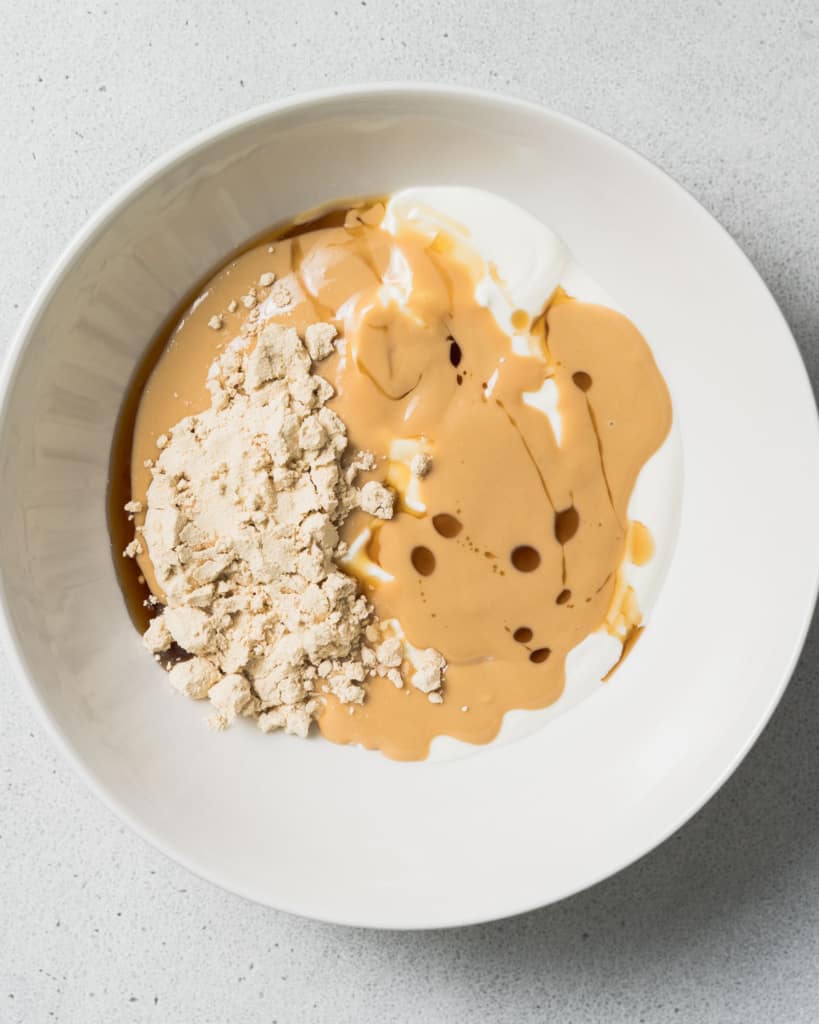 Yogurt, peanut butter and maple syrup in a bowl.