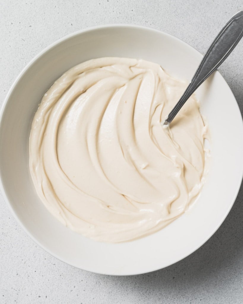 Spoon in a bowl with yogurt mixture.