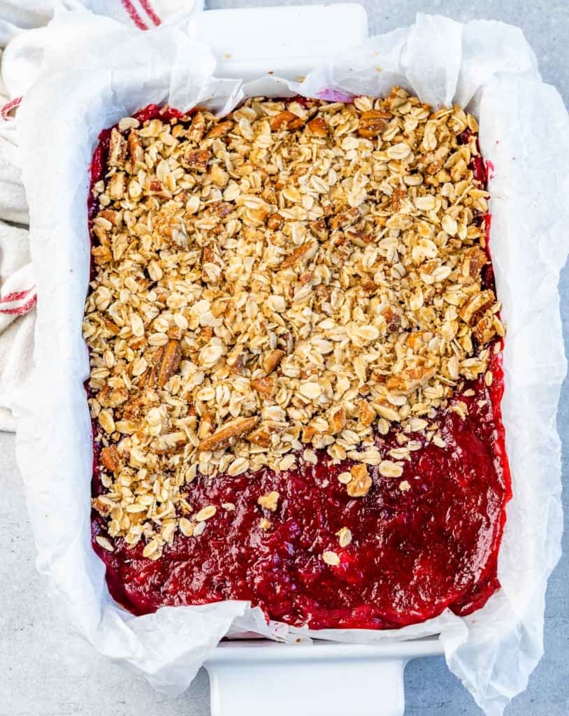 Assembling cranberry bars with oat topping.