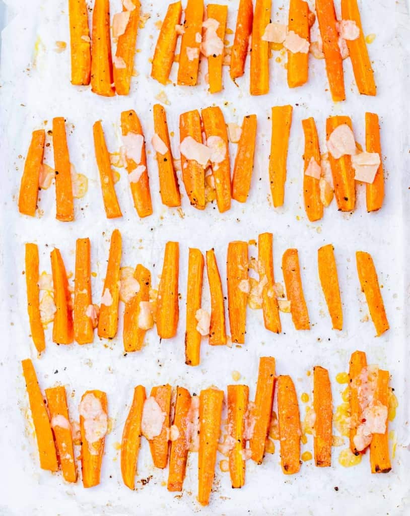 Tossing carrot fries with shaved parmesan.