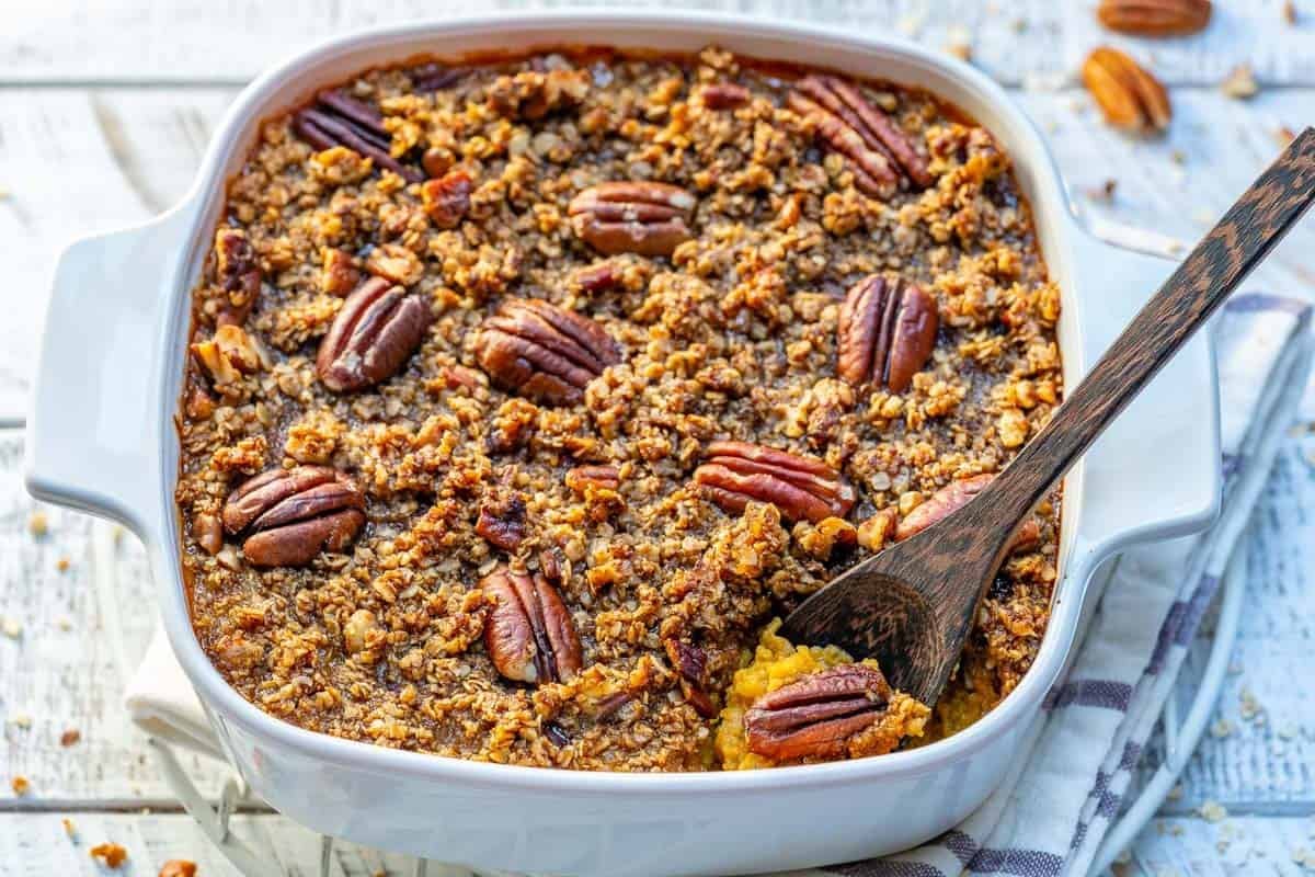 a casserole dish with butternut squash topped with pecan crumble.