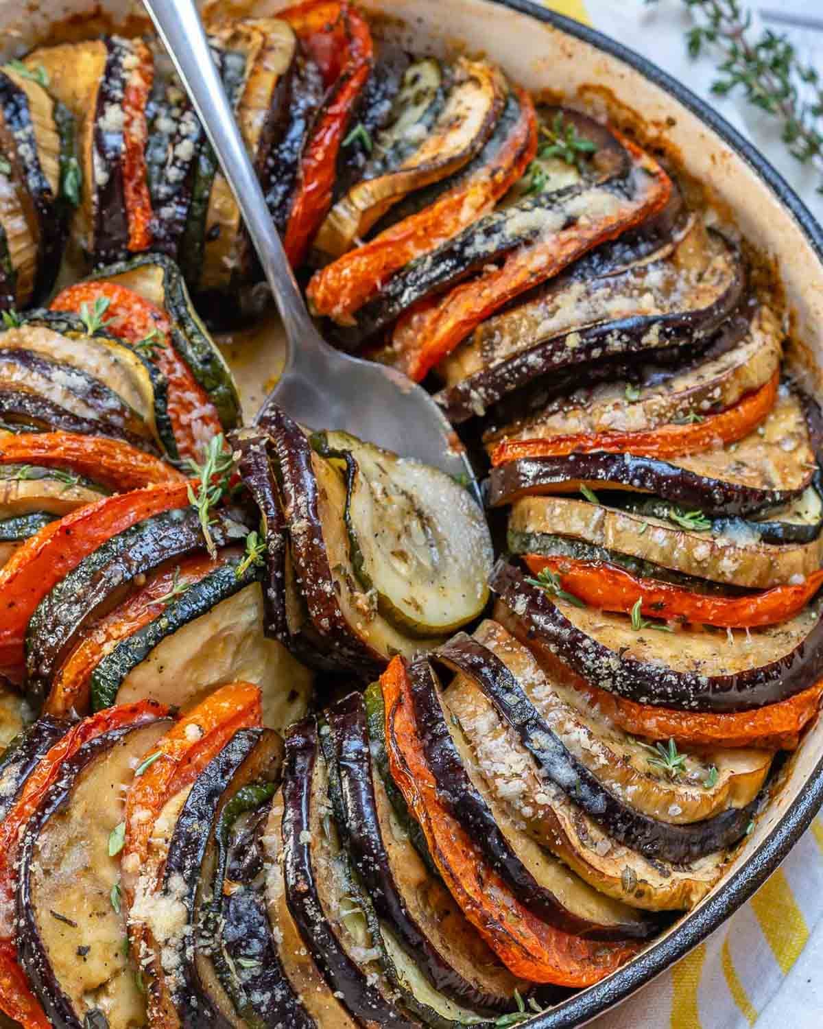 eggplant and zucchini gratin baked in a dish with spoon in it.
